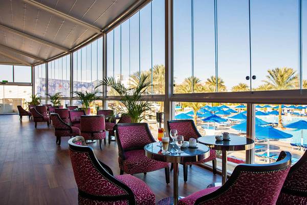 Lounge-Bereich des Pickalbatros Dana Beach Resort mit Blick auf den Pool und Palmen.