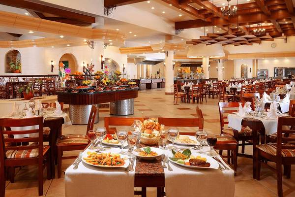Restaurant im Pickalbatros Dana Beach Resort mit vielen gedeckten Tischen und einer großen Speisenauswahl.