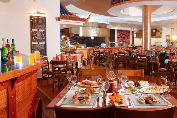 Innenansicht des Restaurants im Pickalbatros Dana Beach Resort mit gedeckten Tischen und serviertem Essen.