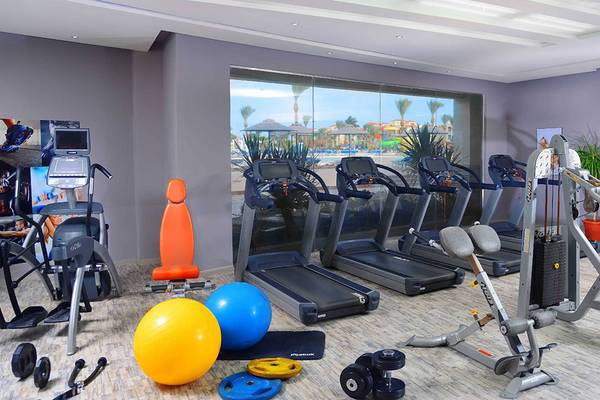 Fitnessstudio im Hotel Pickalbatros Dana Beach Resort mit Laufbändern, Hanteln und anderen Geräten.