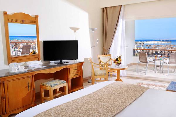 Hotelzimmer im Pickalbatros Dana Beach Resort mit Meerblick, Fernseher, Schreibtisch und Balkonmöbeln.
