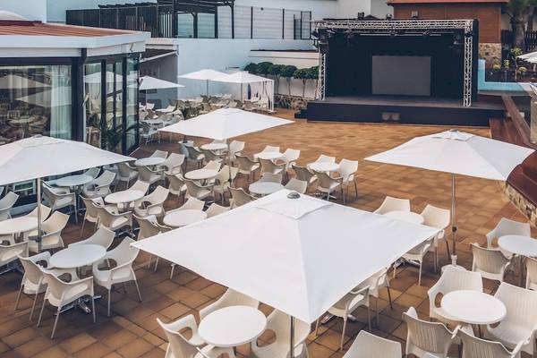 Oberirdische Terrasse des Iberostar Las Dalias Hotels mit Tischen, Stühlen und Sonnenschirmen.