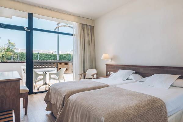 Doppelzimmer im Iberostar Las Dalias Hotel mit zwei Betten, Tisch, Stühlen und Balkon.