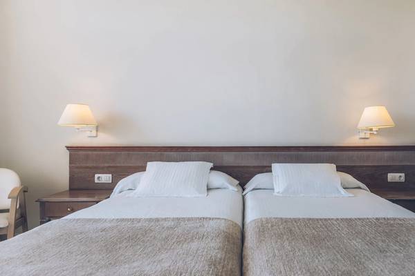 Doppelbettzimmer im Iberostar Las Dalias Hotel mit weißen Laken und Kissen.