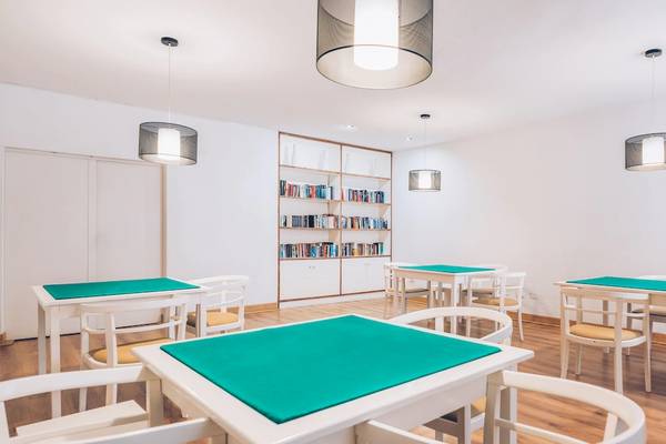 Speisesaal im Iberostar Las Dalias Hotel mit weißen Tischen und Stühlen, Bücherregal und Deckenlampen.