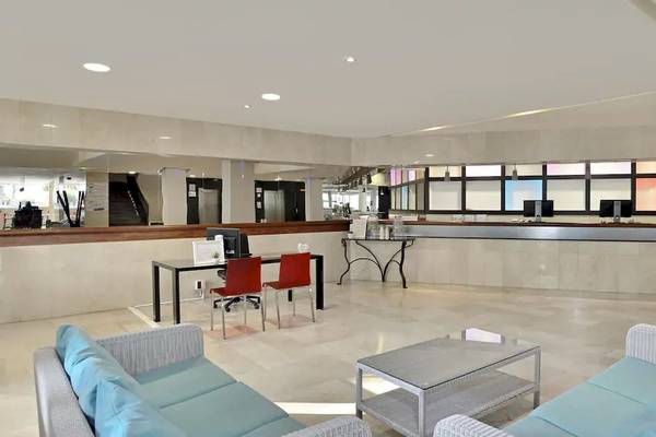 Innenbereich der Lobby des Sol Barbados Hotels mit Rezeptionstresen, Tischen und Stühlen.