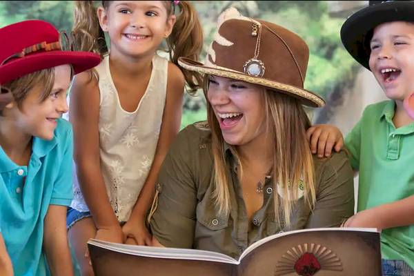 Kinder mit Hüten lesen das Buch La Leyenda de Katmandu