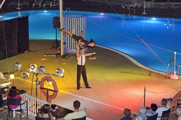 Akrobaten führen eine Show über einem Swimmingpool im Sol Barbados Hotel auf.