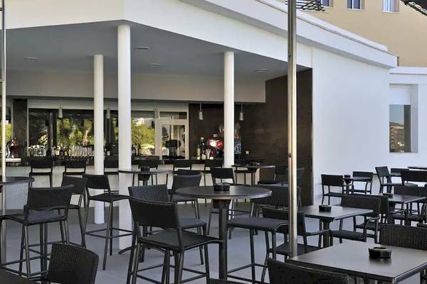 Außenbereich des Sol Barbados Hotels mit Bar und Tischen auf der Terrasse.