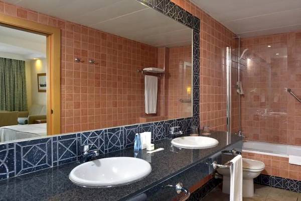 Hotel Sol Barbados Badezimmer mit zwei Waschbecken, Badewanne und Toilette.