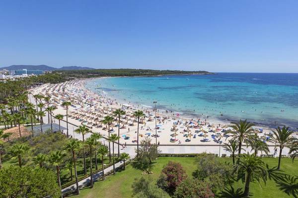 Luftaufnahme des Hipotels Bahia Grande Strandes mit vielen Gästen, Palmen und türkisfarbenem Meer