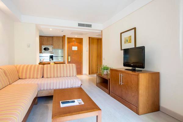 Wohnzimmer im Hipotels Bahia Grande mit Sofa, Fernseher und Kaffeetisch.