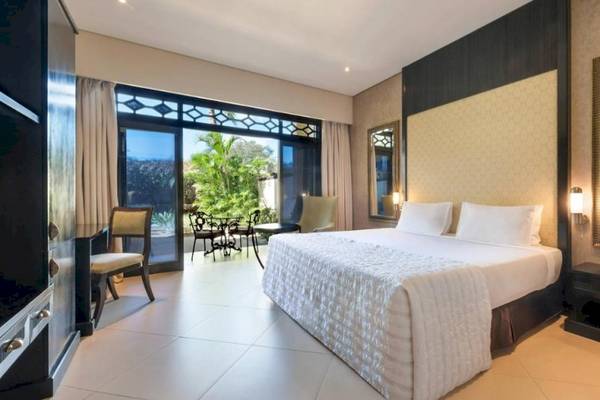 Innenansicht eines Hotelzimmers im Le Meridien Ile Maurice mit großem Bett und Balkon