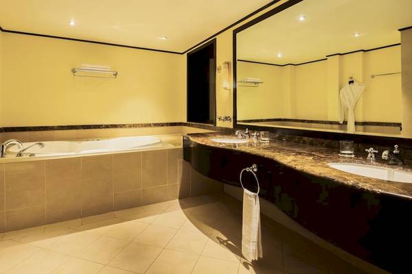 Luxuriöses Badezimmer im Le Meridien Ile Maurice Hotel mit Badewanne und Doppelwaschbecken.