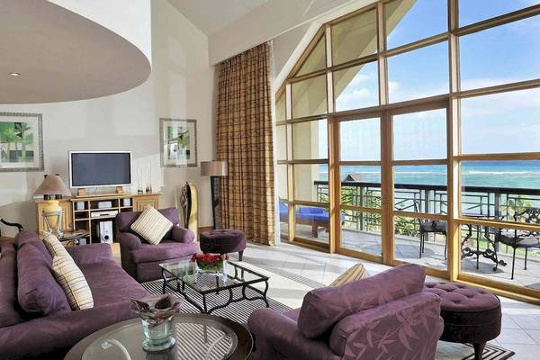 Wohnzimmer im Le Meridien Ile Maurice mit Blick auf das Meer, großen Fenstern und Möbeln.