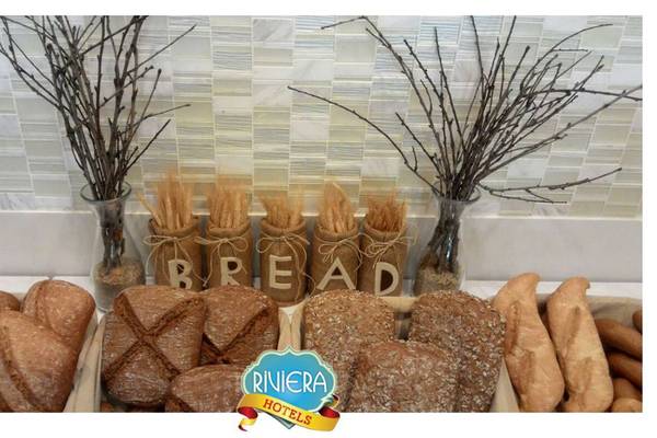 Verschiedene Brotsorten im Riviera Hotel & Spa mit dekorativen Vasen und Zweigen.
