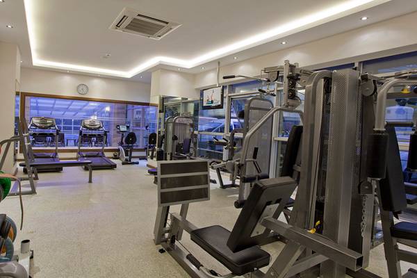 Fitnessstudio im Riviera Hotel & Spa mit verschiedenen Trainingsgeräten und Blick auf den Außenbereich.