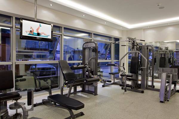 Fitnessstudio im Riviera Hotel & Spa mit Trainingsgeräten und großen Fenstern.
