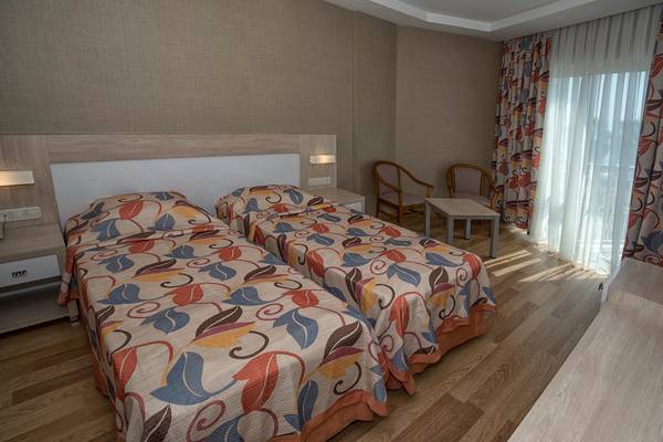 Doppelzimmer im Riviera Hotel & Spa mit zwei Betten, Nachttischen und Stühlen.