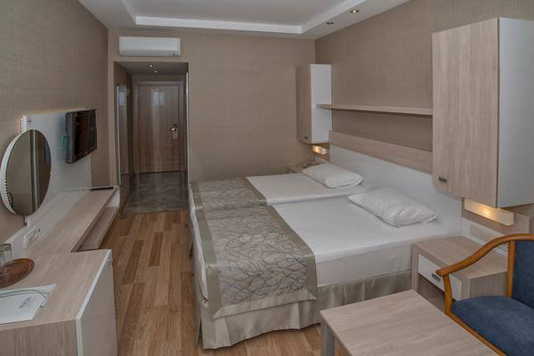 Ein Doppelbettzimmer im Riviera Hotel & Spa mit zwei Betten, einem Fernseher, einem Spiegel und einem Kleiderschrank.