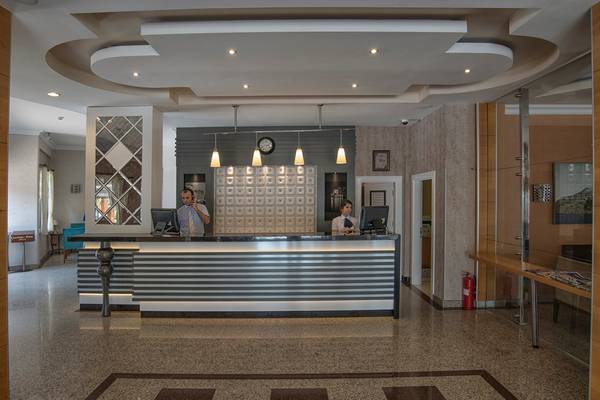 Empfangsbereich des Riviera Hotel & Spa mit zwei Mitarbeitern am Empfangstresen