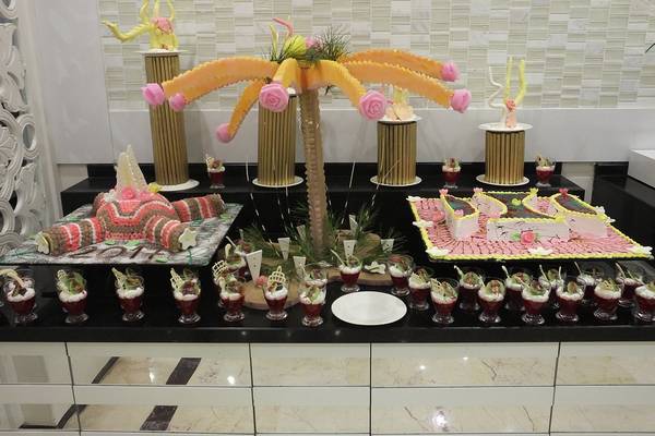 Buffet im Riviera Hotel & Spa mit einer großen Palmen-Dekoration und verschiedenen Desserts.