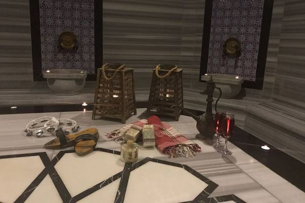 Spa Bereich im Riviera Hotel & Spa mit Tisch, zwei Laternen, zwei Weinschälchen, Handtüchern, Duftkerzen und Schlappen.