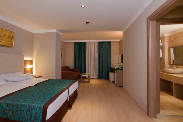 Doppelzimmer im Riviera Hotel & Spa mit zwei Betten, bequemen Sesseln und Badezimmer