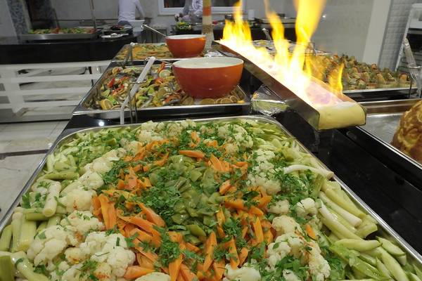 Buffet-Tisch mit verschiedenen Gemüsesorten und Feuer im Riviera Hotel & Spa.