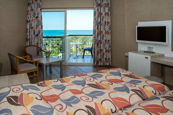Zimmer im Riviera Hotel & Spa mit Meerblick, Fernseher und Balkonmöbeln.