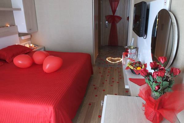 Valentinstags-Dekoration im Zimmer des Riviera Hotel & Spa mit roten Ballons und Herz-Lichtern auf dem Boden.