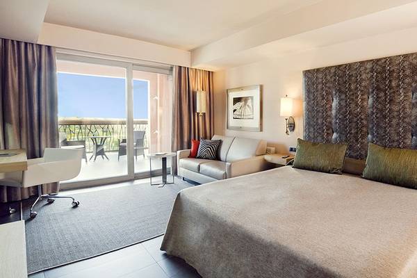Hotelzimmer im Lopesan Baobab Resort mit Bett, Couch, Schreibtisch und Balkon