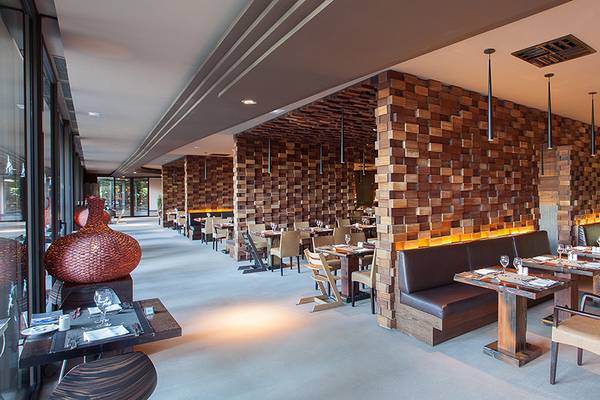 Innenansicht des Lopesan Baobab Resorts Restaurants mit Holzwänden und braunen Lederbänken.