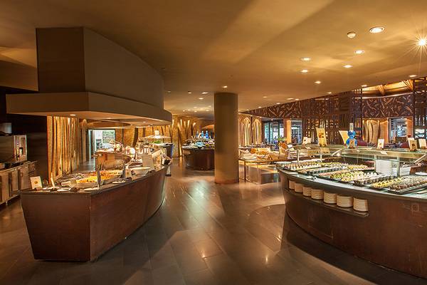 Buffetbereich im Lopesan Baobab Resort mit verschiedenen Speisen und Holzdesignelementen.