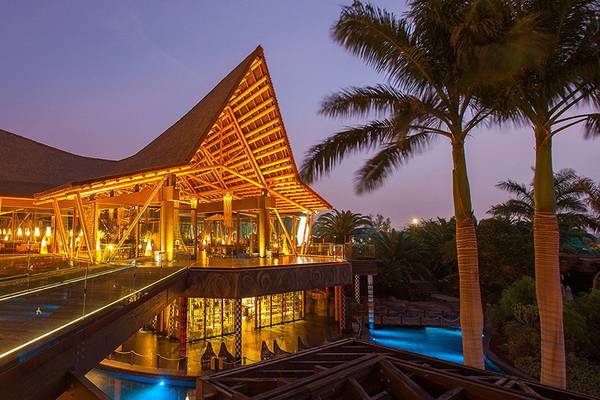 Abendansicht des Lopesan Baobab Resorts mit beleuchteter Architektur und Swimmingpool
