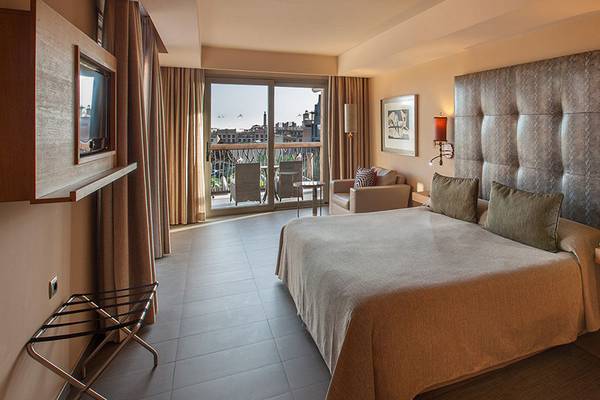Hotelzimmer im Lopesan Baobab Resort mit großem Bett, Balkon und modernen Möbeln.