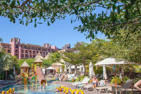Poolbereich des Lopesan Baobab Resorts mit Wasserrutsche und Sonnenliegen