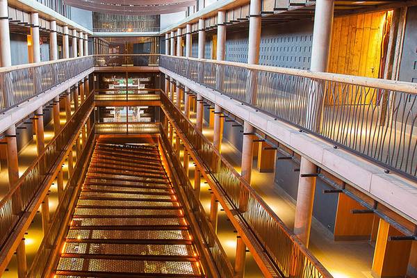 Innenansicht des Lopesan Baobab Resorts mit mehreren Stockwerken, Treppen und gelben Lichtern.