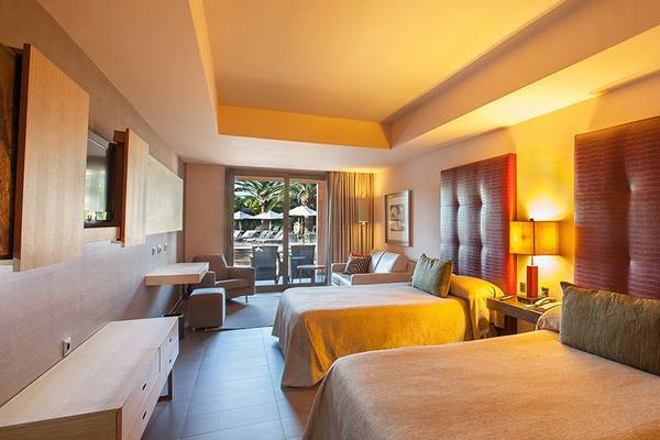 Doppelzimmer im Lopesan Baobab Resort mit zwei Betten, modernem Design und Ausblick auf die Terrasse.