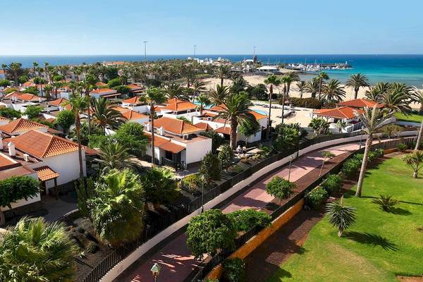 Luftaufnahme des Barcelo Fuerteventura Castillo Resorts mit vielen Häusern und einem langen Strand.