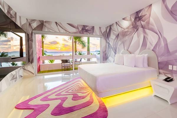 Innenansicht eines Hotelzimmers im Temptation Cancun Resort mit Blick auf das Meer und eine Terrasse.