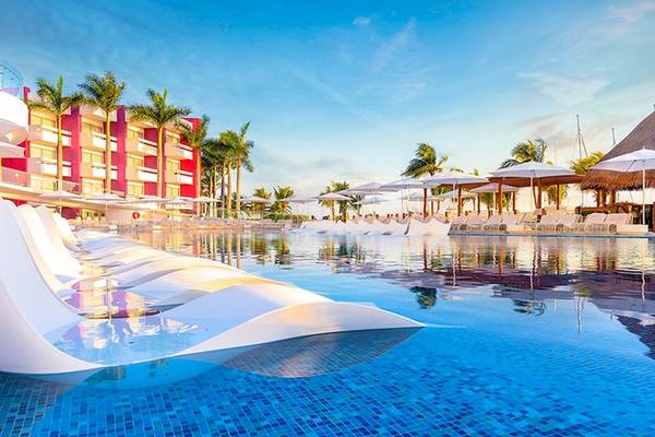 Außenpool mit weißen Liegen und Sonnenschirmen im Temptation Cancun Resort.