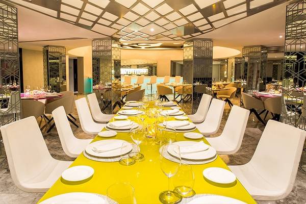 Restaurantbereich im Temptation Cancun Resort mit langer Tafel und weißen Stühlen.