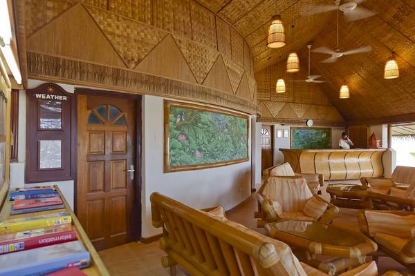 Innenansicht der Lobby des Thulhagiri Island Resorts mit Möbeln und Wandmalerei.