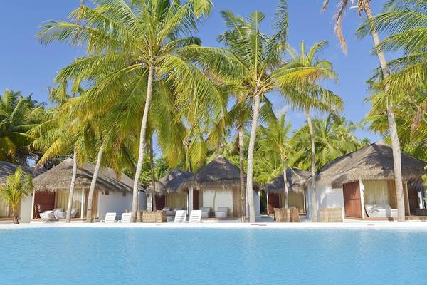Pool und Hütten des Thulhagiri Island Resorts unter Palmen