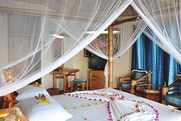 Thulhagiri Island Resort Zimmer mit Bett und Blumendekoration