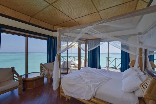 Bettzimmer im Thulhagiri Island Resort mit Blick auf das Meer.