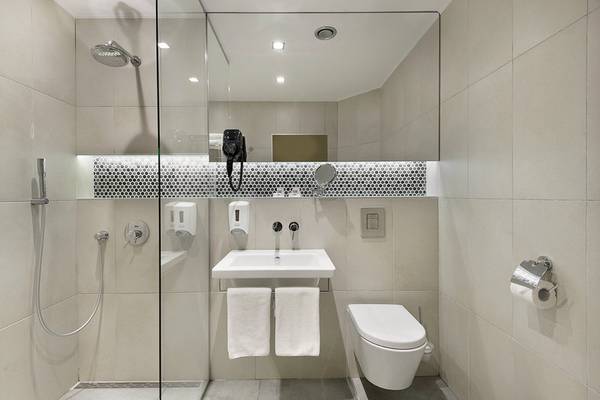 Badezimmer des HVD Club Bor Hotels mit Glasdusche, Toilette und Waschbecken.