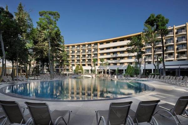 Außenbereich des HVD Club Bor Hotels mit Swimmingpool und Sonnenliegen.