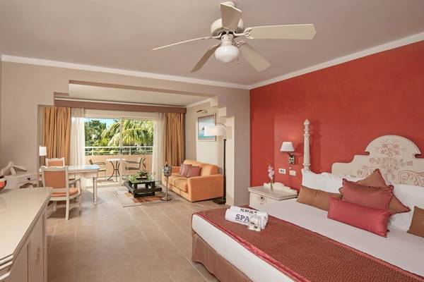 Innenansicht eines Hotelzimmers im Iberostar Selection Varadero mit Bett, Wohnzimmerbereich und Balkon.